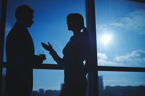 Businessman and businesswoman communicating by the window — Stock Photo, Image