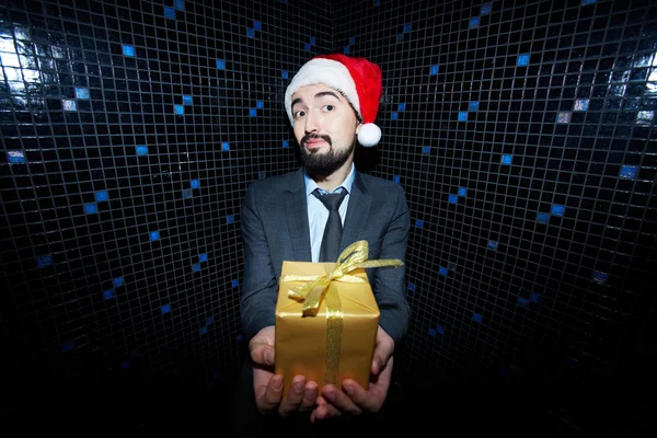 Businessman in Santa cap holding giftbox — Stock Photo, Image