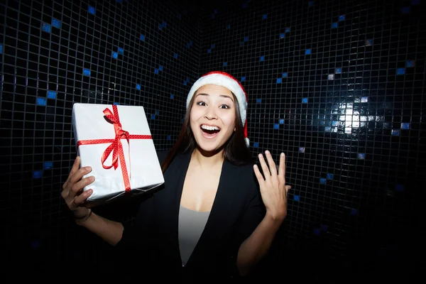 Businesswoman in Santa cap holding present — Stock Photo, Image