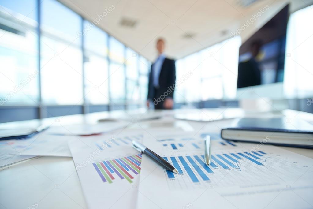 Papers with financial data on office table