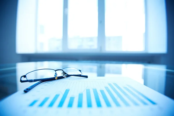 Eyeglasses on business report — Stock Photo, Image