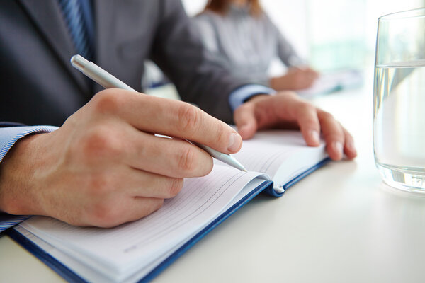 Businessman checking  notes in notebook