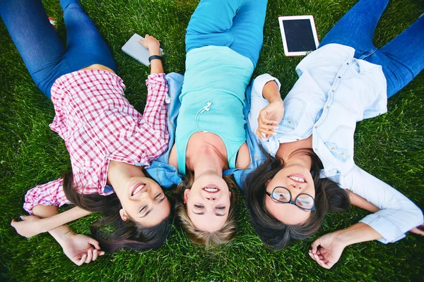 Tiener meisjes liggend op groen gras — Stockfoto