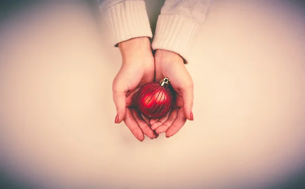 Christmas toy ball on hands — Stock Photo, Image