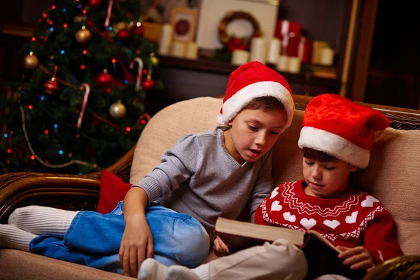 Bambini a Babbo Natale caps lettura — Foto Stock