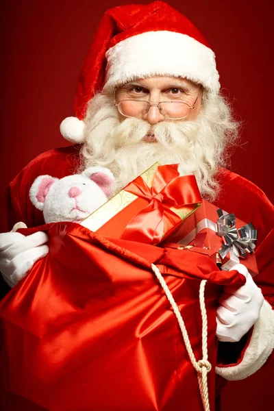 Santa bedrijf zak met geschenken — Stockfoto