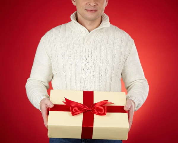 Man in white pullover holding gift — Stock Photo, Image