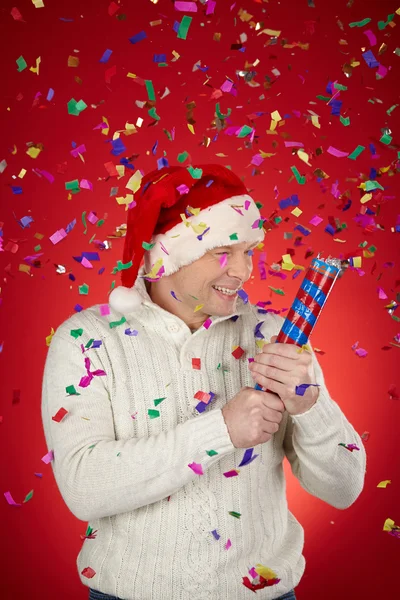Man in Santa cap with confetti cracker — Stock Photo, Image
