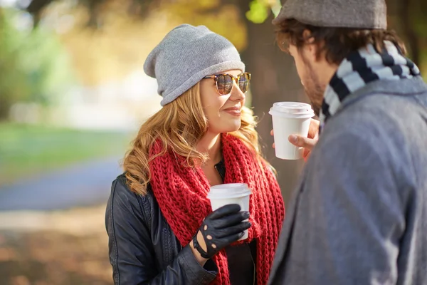 Couple drinking coffee in autumn park — Stock Photo, Image