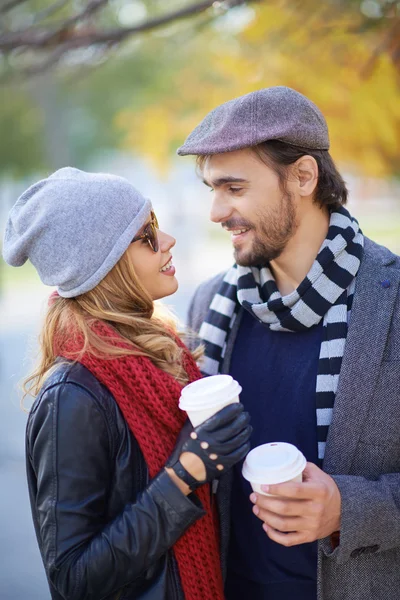 Couple drinking coffee in autumn park — Stock Photo, Image