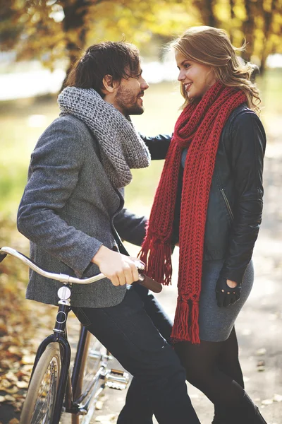 Casal com bicicleta no parque de outono — Fotografia de Stock