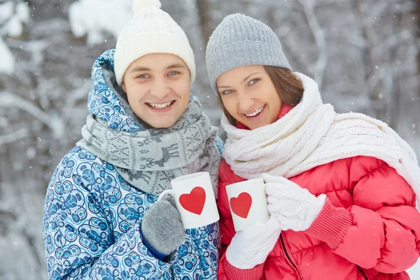 Paar mit Tassen mit roten Herzen — Stockfoto