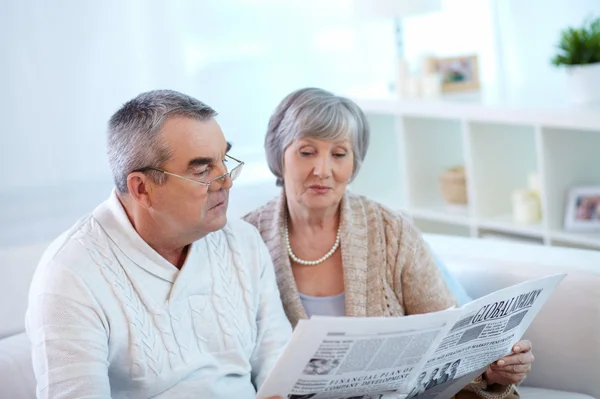 先輩夫婦が新聞を読んで — ストック写真