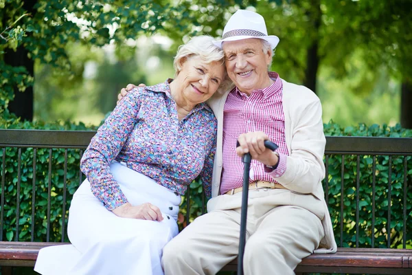 Happy seniors sitting on bench — Stock Photo, Image