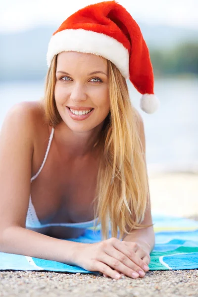 Mulher tomando banho de sol em chapéu de Santa — Fotografia de Stock