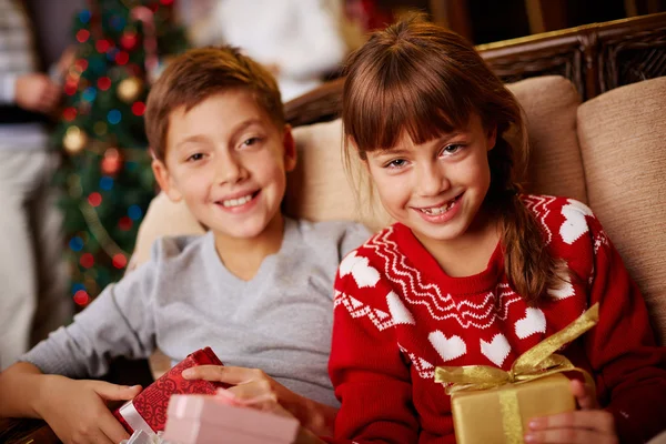 Mädchen und Junge mit Weihnachtsgeschenken Stockbild
