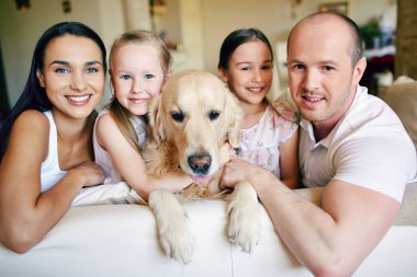 Aile ile kanepede oturan köpek