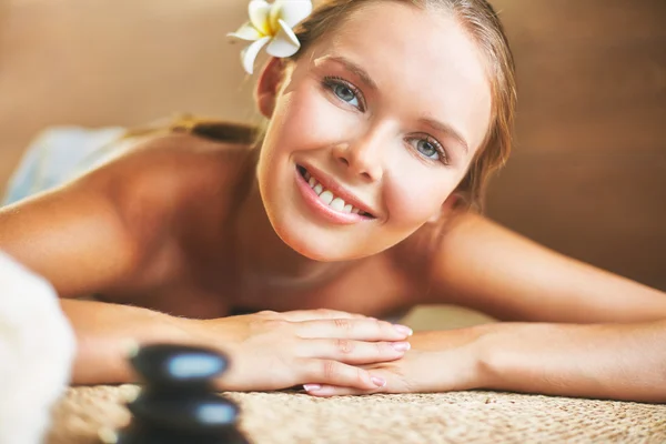 Chica sonriente acostada en el salón de spa — Foto de Stock