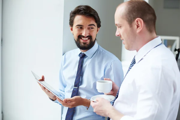 Businessman with touchpad showing data to colleague — Stock Photo, Image