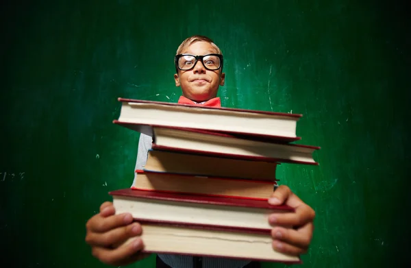 Pupil holding stack of textbooks — Stock Photo, Image