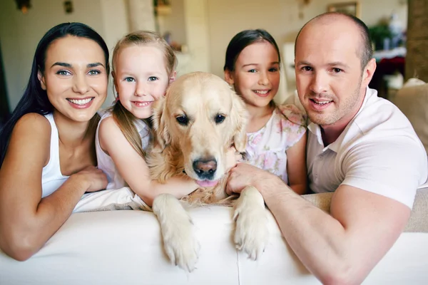 Aile ile kanepede oturan köpek — Stok fotoğraf