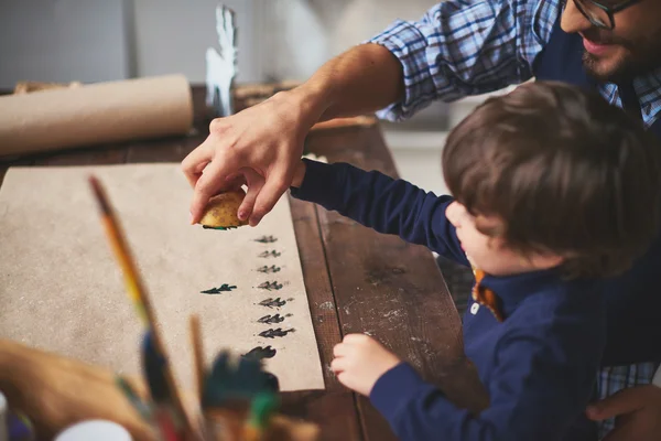 Father and son practicing potato printing — Stock Photo, Image