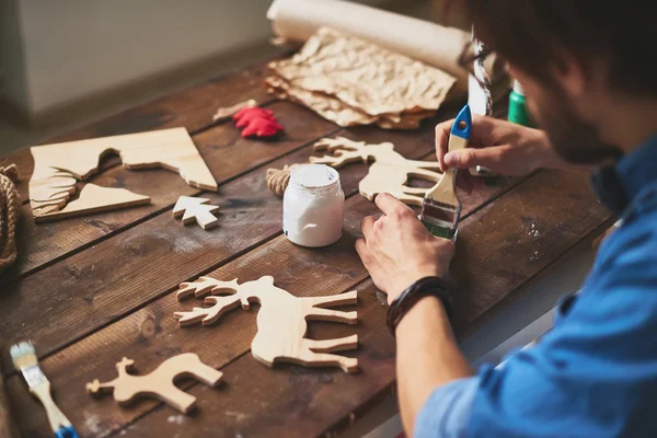 Artesano pintando ciervos de madera —  Fotos de Stock