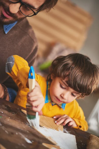 Kid painting wooden xmas tree — Stock Photo, Image