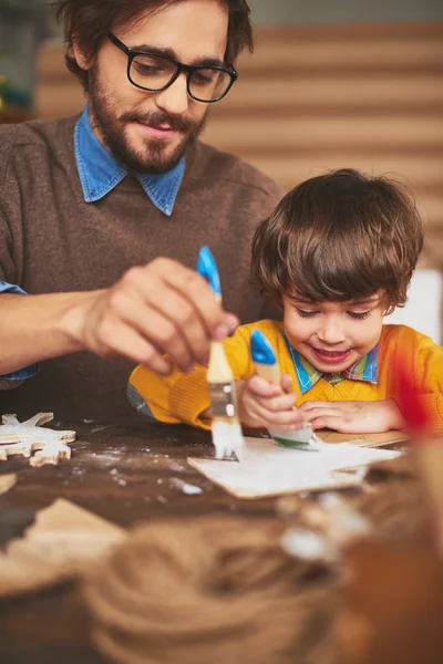 Pai e filho pintura árvore xmas de madeira — Fotografia de Stock