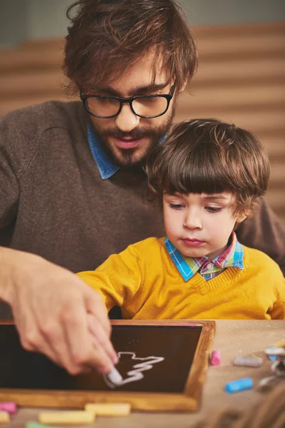 Padre enseñando a su hijo a dibujar con tiza — Foto de Stock