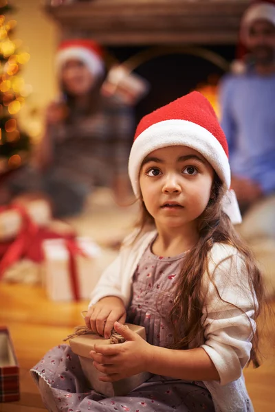 Mädchen in Weihnachtsmannmütze mit Geschenk — Stockfoto