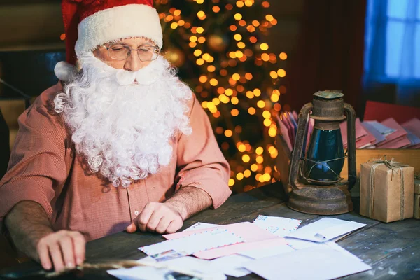 Santa patrząc na stos listów — Zdjęcie stockowe