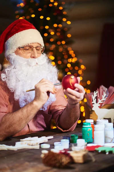 Санта Клаус рисует игрушечный шар — стоковое фото
