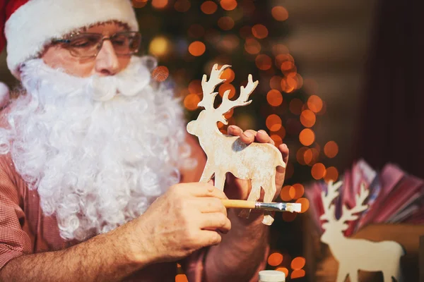 Santa Claus holding wooden deer — Stock Photo, Image