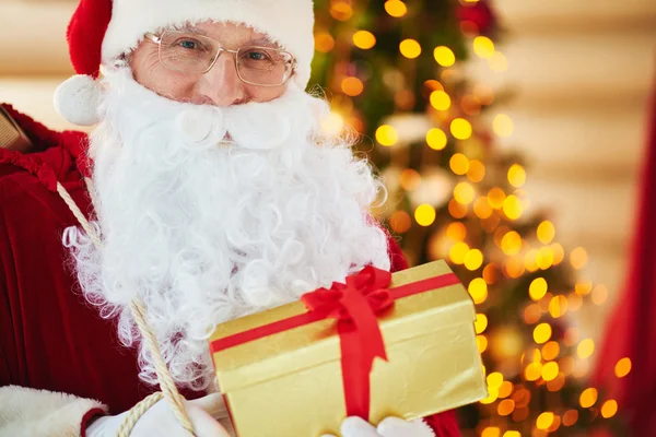 Santa Claus sosteniendo caja de regalo de oro — Foto de Stock