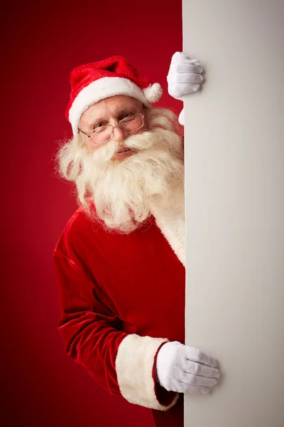Санта-Клаус выглядывает из билборда — стоковое фото