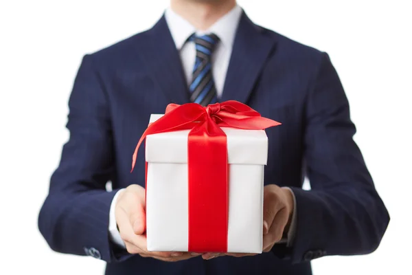 Uomo d'affari in giacca e cravatta contenente una scatola regalo — Foto Stock