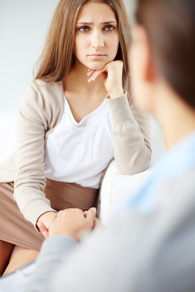 Sad woman looking at psychiatrist
