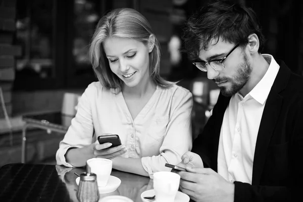 Coppia utilizzando smartphone in caffè — Foto Stock