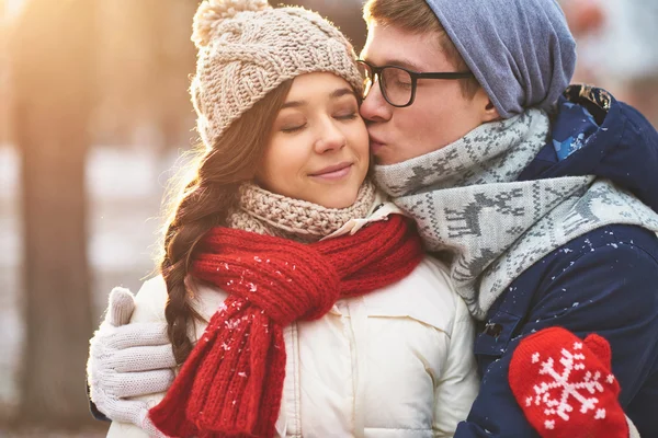 Man kissing his girlfriend on cheek — Stock Photo, Image