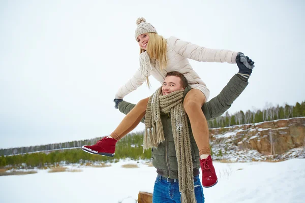 Man carrying girlfriend on shoulders — Stock Photo, Image