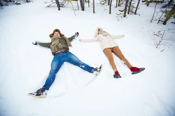 Casal deitado na neve — Fotografia de Stock