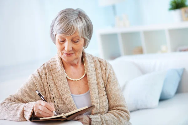 Senior woman making notes — Stock Photo, Image