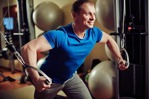 Hombre levantando pesas en la máquina de ejercicios —  Fotos de Stock