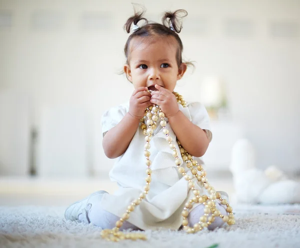 Little girl playing with beads — Stock Photo, Image