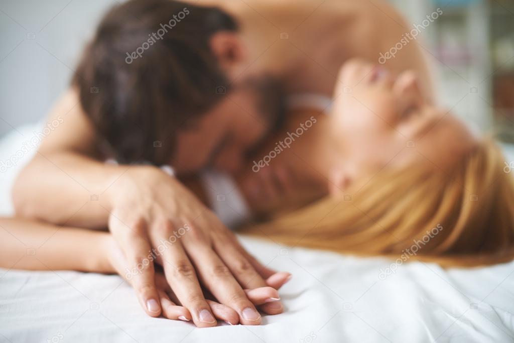 Man kissing woman in bed
