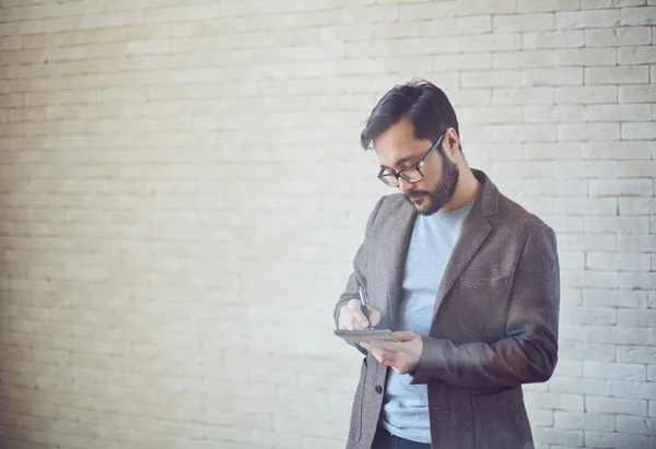 Businessman making notes in notepad — Stock Photo, Image