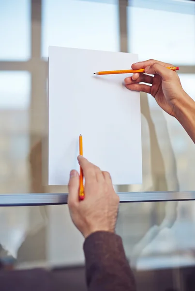 Manos masculinas apuntando al papel — Foto de Stock