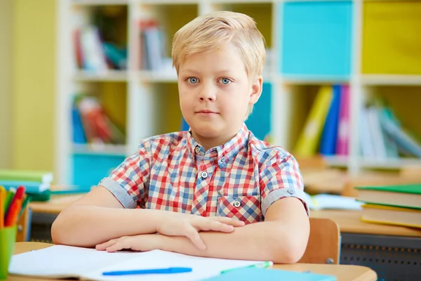 Schoolboy by desk in classroom — Stock Photo, Image