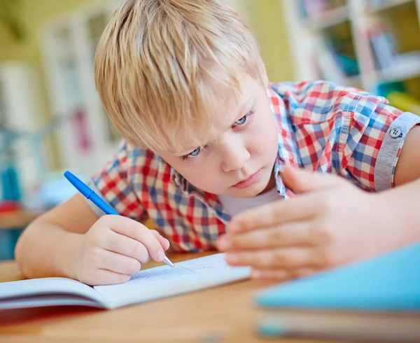 Schoolboy looking at crib on palm — Stock Photo, Image